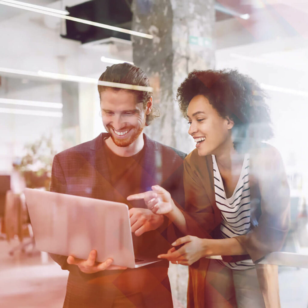 Coworkers looking at projects on a laptop